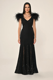 Long knitted evening dress with ostrich feathers on the shoulders, sequined waist, back and hem.